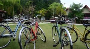 drei Fahrräder, die nebeneinander auf dem Rasen geparkt sind in der Unterkunft Satun Boutique Resort in Satun + 155 Fotos