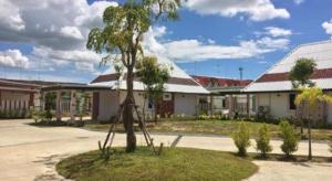 een kleine boom voor een gebouw bij Suanrak Resort in Suphan Buri