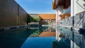 een zwembad naast een gebouw bij Petit Hotel in Thu Dau Mot