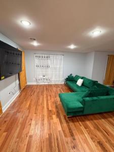 een woonkamer met een groene bank en houten vloeren bij The great homes in East Orange
