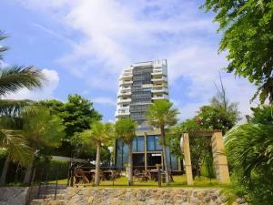 ein hohes Gebäude mit Palmen davor in der Unterkunft Blue Wave Hotel Hua Hin in Hua Hin