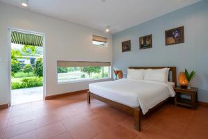 ein Schlafzimmer mit einem großen weißen Bett und einem Fenster in der Unterkunft Chay Lap Farmstay Phong Nha in Ðá Lòn + 57 Fotos