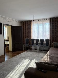 een woonkamer met stoelen, een bank en een tafel bij Gulbara Guest House in Toguz-Bulak