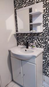 een badkamer met een witte wastafel en een spiegel bij WloterStyl 1 in Warschau