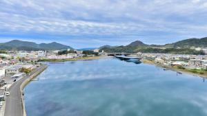 a view of a river with a city and a bridge at First Inn Haiki in Sasebo