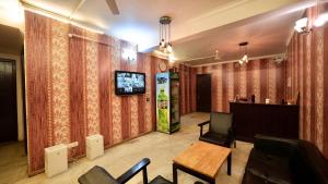 a living room with curtains and a tv on a wall at Hotel Rustam Residency sec-39 in Gurgaon +19 photos