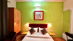 a bed in a room with a green wall at Hotel Rustam Residency sec-39 in Gurgaon