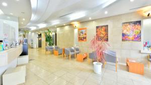 a lobby with a waiting area with tables and chairs at First Inn Haiki in Sasebo