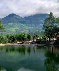 a large body of water with mountains in the background at Sutedjo Telaga bedakah in Bedakah