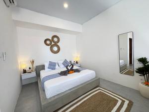 a white bedroom with a large bed and a mirror at Manik Tropicana Loft in Canggu +57 photos
