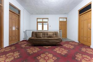 a couch sitting in the middle of a room with two doors at Sutedjo Telaga bedakah in Bedakah
