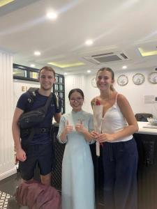 een groep van drie personen die poseren voor een foto bij The Elegant Boutique - Hue in Hue