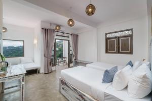 a white bedroom with a bed and a couch at Earthbound Residence in Kandy