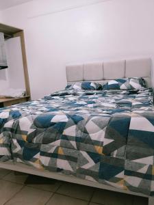 a bed with a colorful blanket and pillows on it at Kinara suites in Kiambu