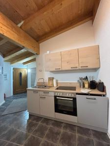 une cuisine avec une cuisinière et des plafonds en bois dans l'établissement Hoamat Apartments, à Oetz