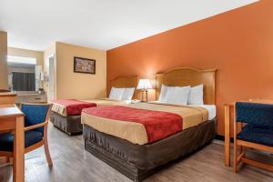 een hotelkamer met twee bedden en een tafel en stoelen bij Econo Lodge Inn & Suites Evergreen in Evergreen