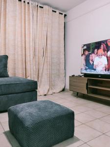a living room with a couch and a tv at Kinara suites in Kiambu