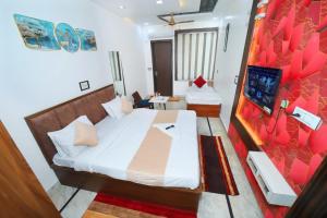 a hotel room with two beds and a desk at Taj Holiday Villa in Agra