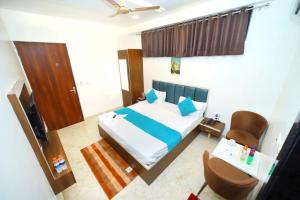a small bedroom with a bed and a chair at Taj Holiday Villa in Agra