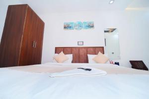 a bedroom with two beds and a wooden cabinet at Taj Holiday Villa in Agra
