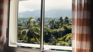 a window with a view of a city at La Kaz Eden * * * * in Les Cocos