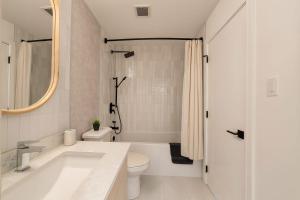 une salle de bain blanche avec une baignoire et des toilettes dans l'établissement Family Stylish 1BR and Den Condo -Apartment with City View, Downtown, Balcony, Free Parking, In-Suite Laundry!, à Calgary 47 autres photos