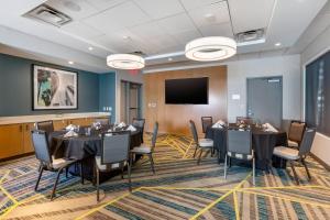 a conference room with tables and chairs and a flat screen tv at Cambria Hotel LAX in El Segundo +79 photos