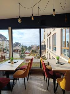 a restaurant with tables and chairs and a large window at Milmari kop in Raška +13 photos