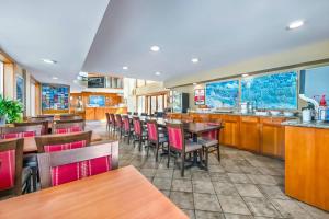 een restaurant met houten tafels en stoelen bij Econo Lodge Inn & Suites in North Vancouver