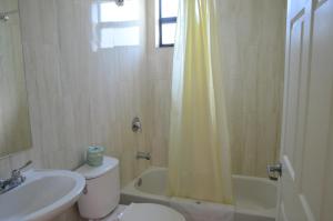 y baño con lavabo, aseo y ducha. en Carl's El Padre Motel, en Miami