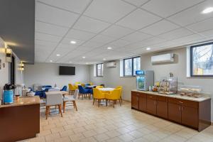 ein Wartezimmer mit gelben und blauen Stühlen und Tischen in der Unterkunft Comfort Inn in Staten Island