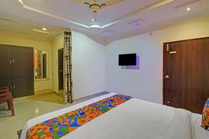 a bedroom with a bed with a colorful blanket on it at FabHotel Sri Balaji Grand in Hyderabad +21 photos
