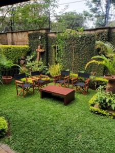 a garden with a table and benches and a cross at Luxury Villas in Gakuo