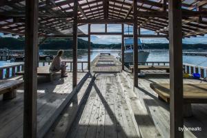 a man sitting on a dock on a boat at Hiogiso in Shima