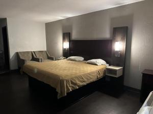 a bedroom with a bed with two pillows on it at Scottish Inns Augusta in Augusta