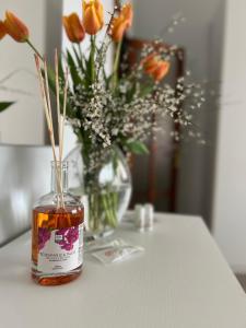 a bottle of whiskey sitting on a table with a vase of flowers at Casa Vacanze Villa Chiara in San Vito