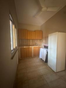 een keuken met een witte koelkast en houten kasten bij La maison de Kalabancoura in Bamako +7 foto's