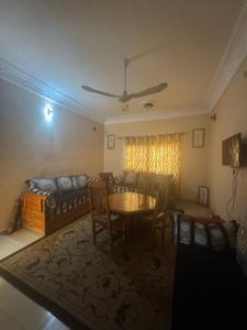 een woonkamer met een tafel, stoelen en een bank bij La maison de Kalabancoura in Bamako