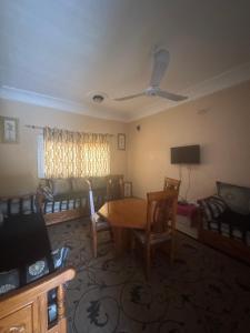 een woonkamer met een tafel en stoelen bij La maison de Kalabancoura in Bamako