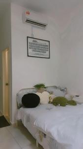 a bed with stuffed animals sitting on top of it at NFF Homestay Sendayan Seremban in Labu