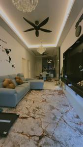 a living room with a blue couch and a television at NFF Homestay Sendayan Seremban in Labu +6 photos