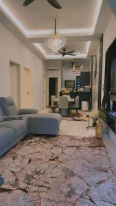a living room with a couch and a dining room at NFF Homestay Sendayan Seremban in Labu