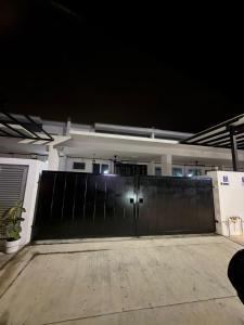 a large black gate in front of a house at night at NFF Homestay Sendayan Seremban in Labu