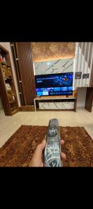 a person holding a remote control in front of a tv at Wantara Villa in Vagamon
