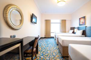 ein Hotelzimmer mit zwei Betten und einem Spiegel in der Unterkunft Al Hidayah Towers Hotel in Mekka