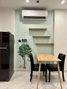 a dining room with a table and a plant on the wall at Alex Vinhomes Grand in Gò Công