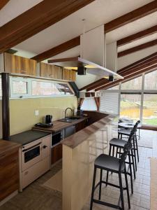 a kitchen with a counter and stools in it at Venero - Apartmani in Dubrave Gornje