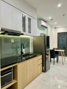 a kitchen with a sink and a stove top oven at Alex Vinhomes Grand in Gò Công