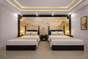 two beds in a room with a painting on the wall at The Elegant Boutique - Hue in Hue
