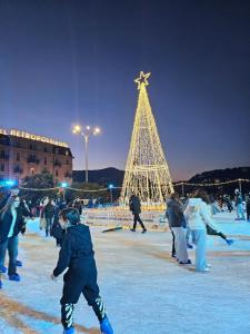 a group of people ice skating in front of a christmas tree at La Perla sul Lago di Como con parcheggio in Como